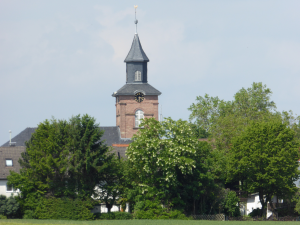 Kirchturm zwischen grünen Bäumen