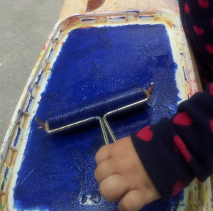 Eine Farbwalze wird in blauer Farbe gewälzt