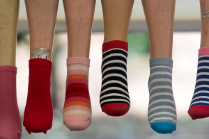 Baumelnde Füße in verschiedenen bunten Socken