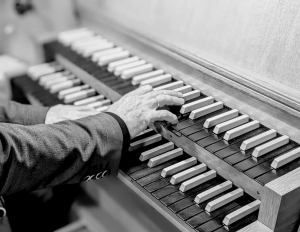 Zwei Hände spielen auf einer Orgel