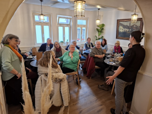 Erwachsene beim zweiten Frühstück in Kleingruppen sitzend