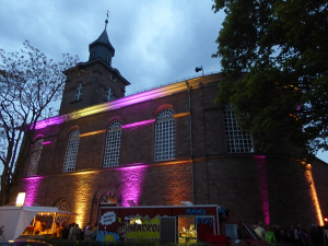 Außenansicht der Kirche mit bunten Lichtern angestrahlt