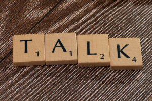 Das Wort TALK gelegt aus Scrabble-Buchstabensteinen