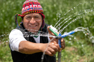 Javier Quispe Valle, Landwirt, Cusco/Peru hält einen Wassersprinkler